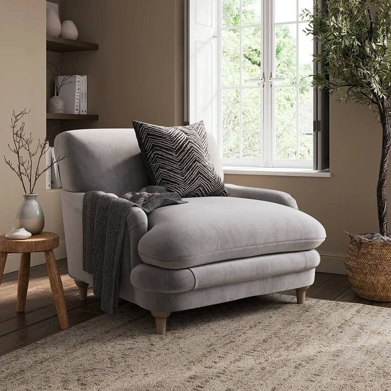 compact grey velvet snuggle chair in small room