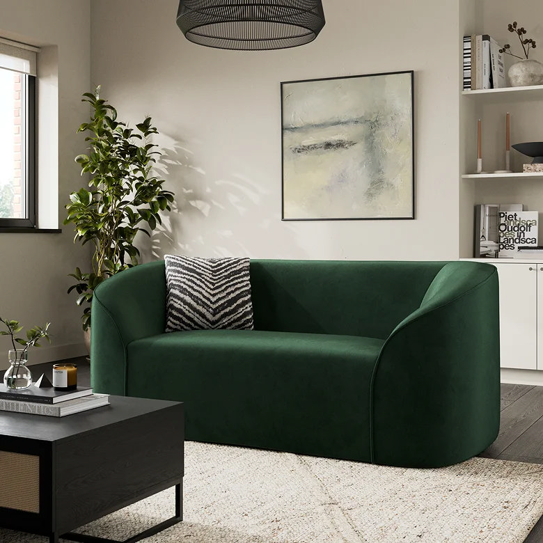 compact dark green curved sofa in small space