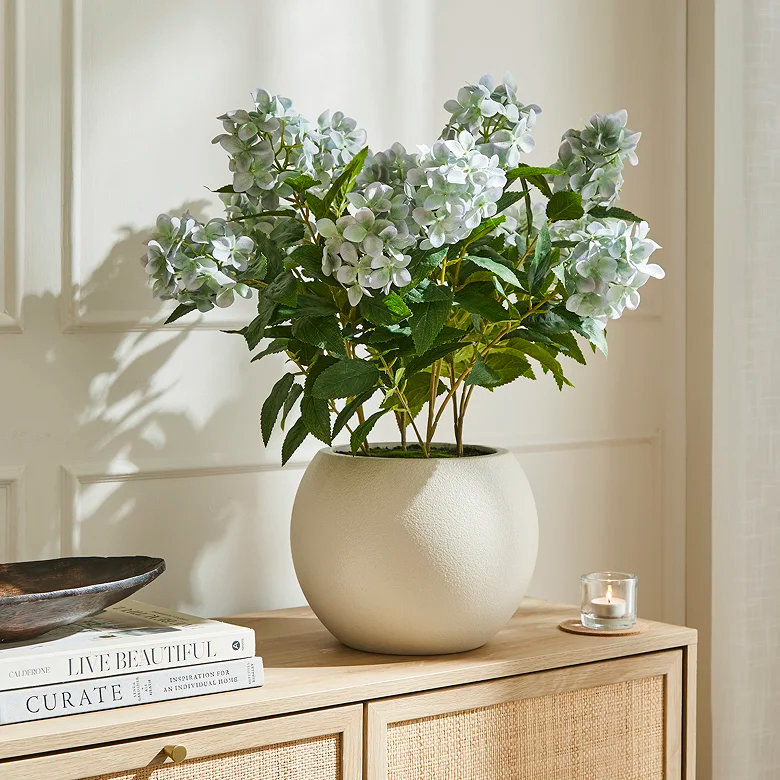 white faux flowers in vase in home office
