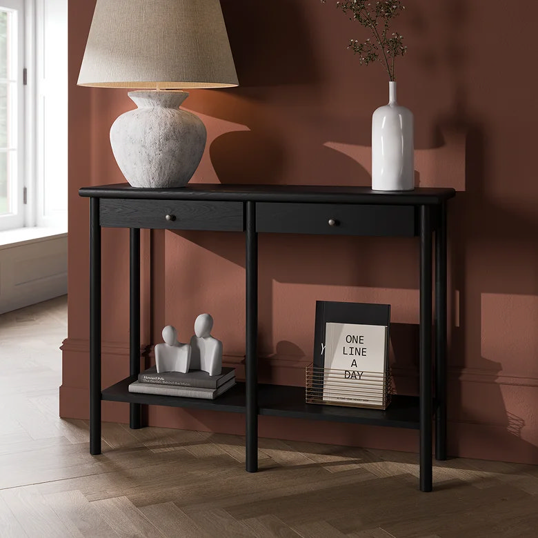 black console table with lamp, vase, books