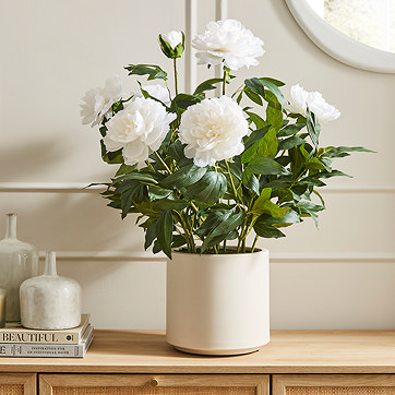 Faux plant in pot on surface