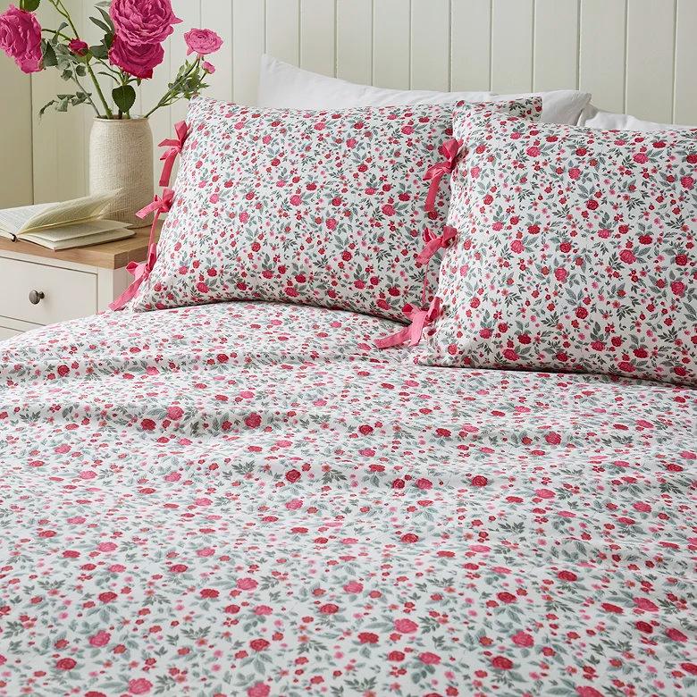 white floral fitted sheet with pink ditsy print and ribbon tie pillowcases