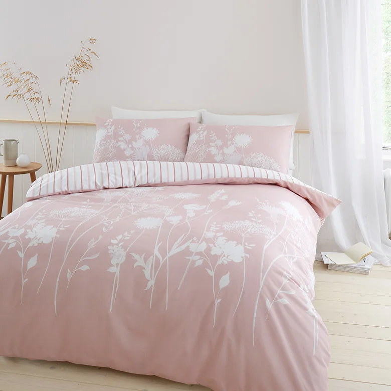 blush pink floral duvet cover set with delicate white botanical print styled in soft neutral bedroom with light airy decor