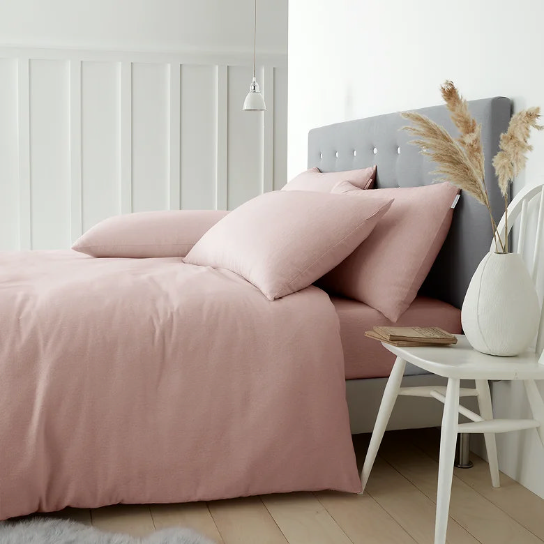 blush pink brushed cotton duvet cover set with matching pillowcases on upholstered headboard bed