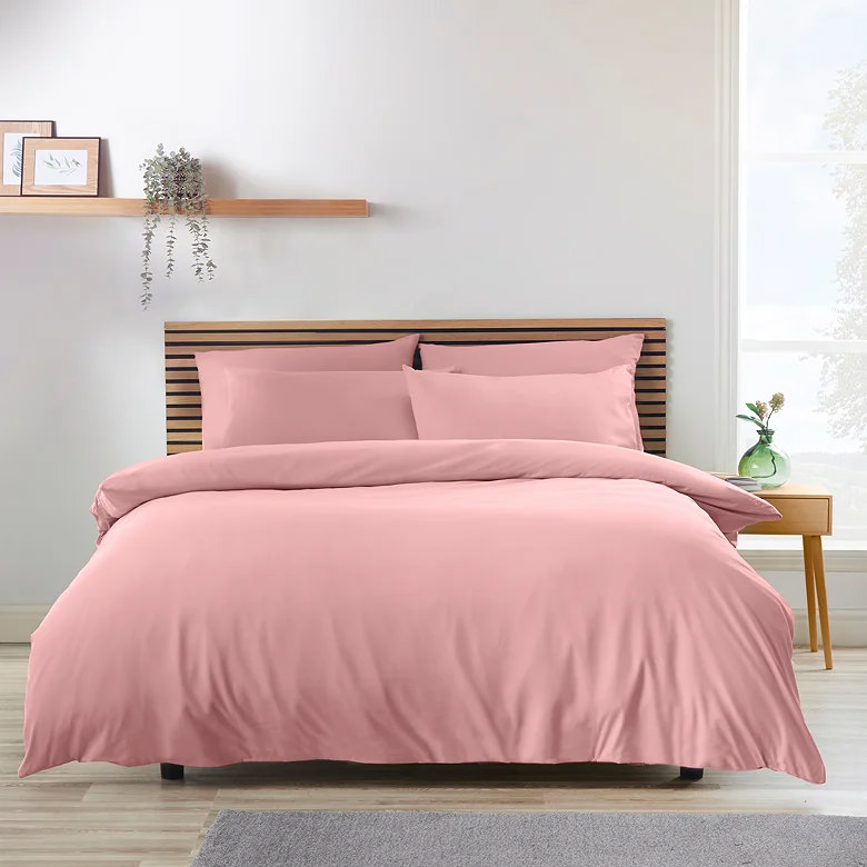 coral pink plain duvet cover set with matching pillowcases on wooden slatted headboard bed
