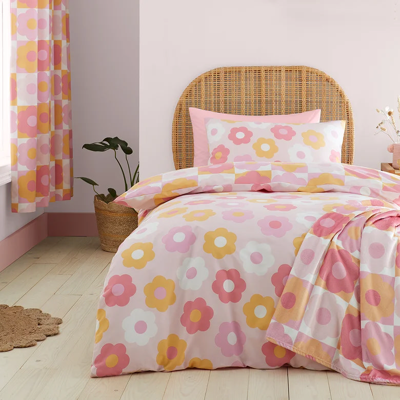 pink and orange retro daisy duvet cover set with matching pillowcase on rattan headboard bed
