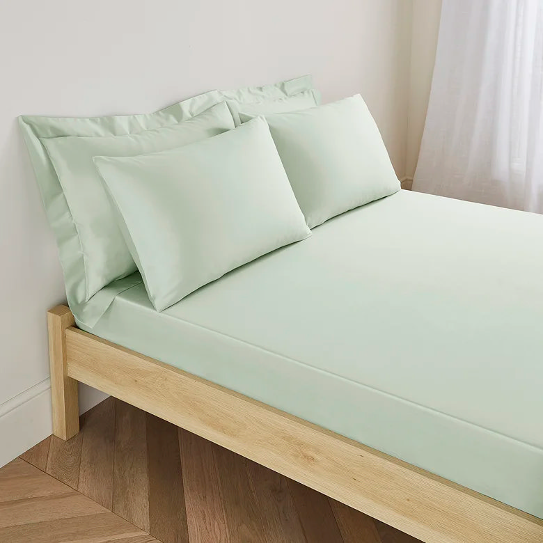 soft sage green fitted sheet set with matching pillowcases in minimalist bedroom