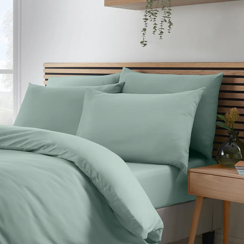 plain green bedding set with soft cotton finish and wooden headboard styling