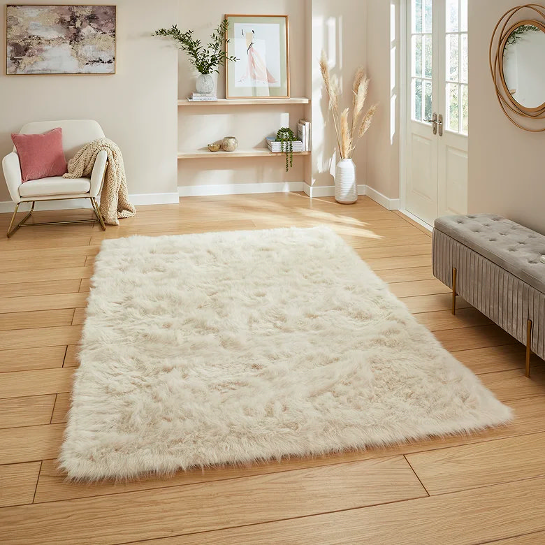 Cosy beige shaggy rug on wooden floor in the centre of a room, showing how a plush neutral rug can warm a minimalist home office or desk nook, add softness underfoot, and zone a workspace in a shared room