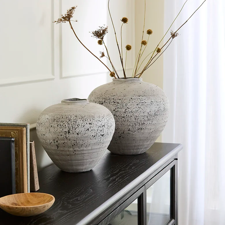 two ceramic vases on top of long cabinet