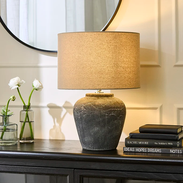lamp and books and faux plants on cabinet