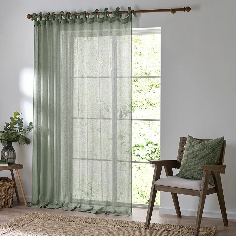 sage green sheer curtain panel in home office