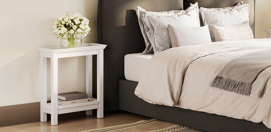 white bedside table with flowers and books