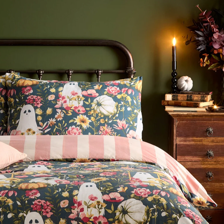 flameless candle on wooden bedside table with books