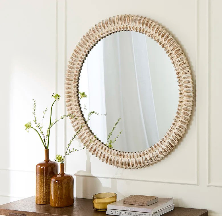 chunky wooden bedroom mirror above chest of drawers