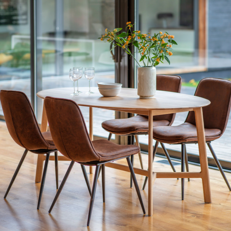 wooden oval dining table with four chairs