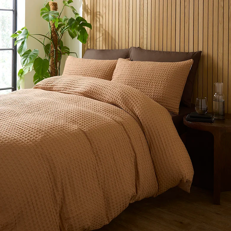 brown earthy autumn bedding, wooden wall