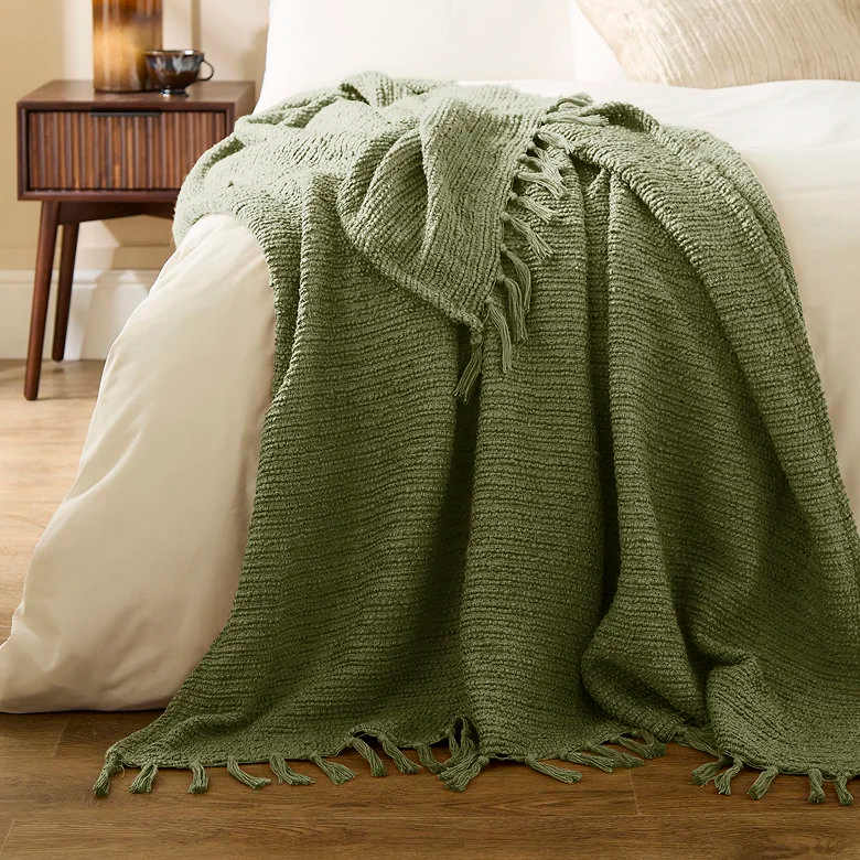green woven boucle throw blanket on bed