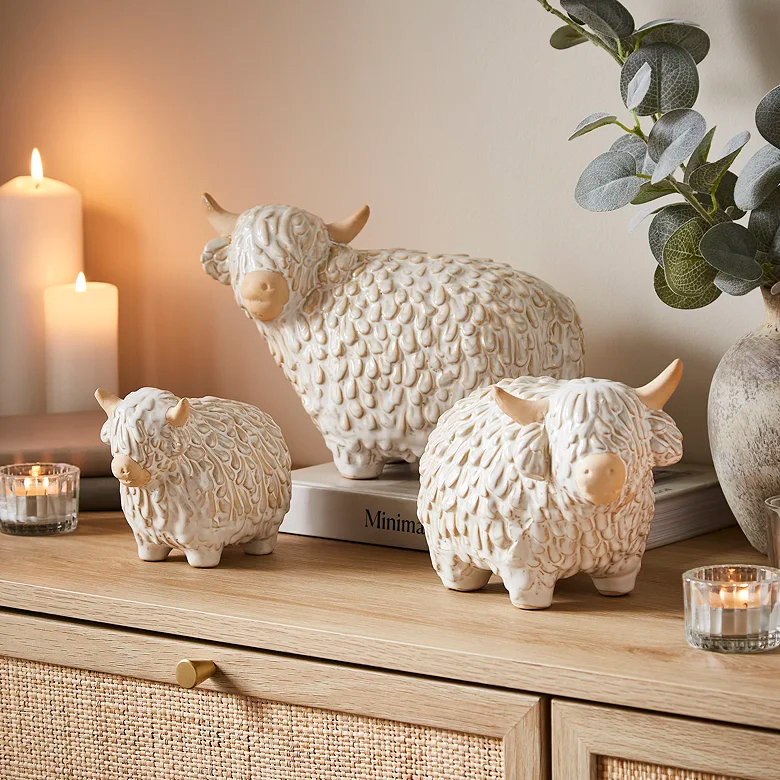 white ceramic highland cows on sideboard