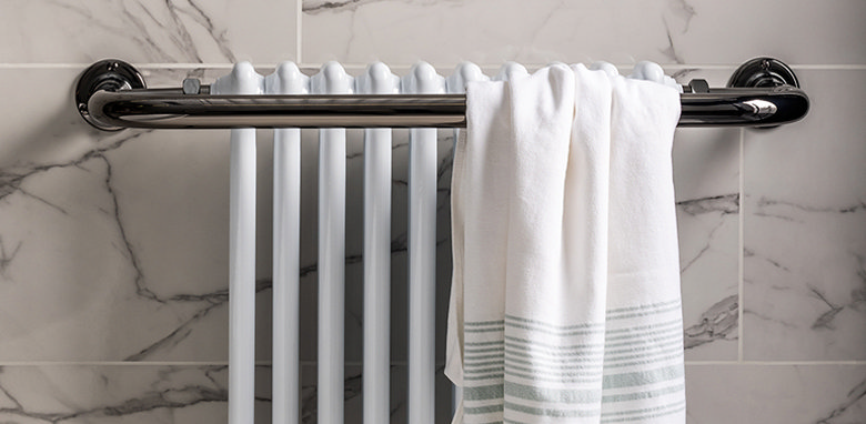 white towel hung over a heated towel rail