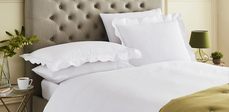 white scallop edge bedding on grey bed