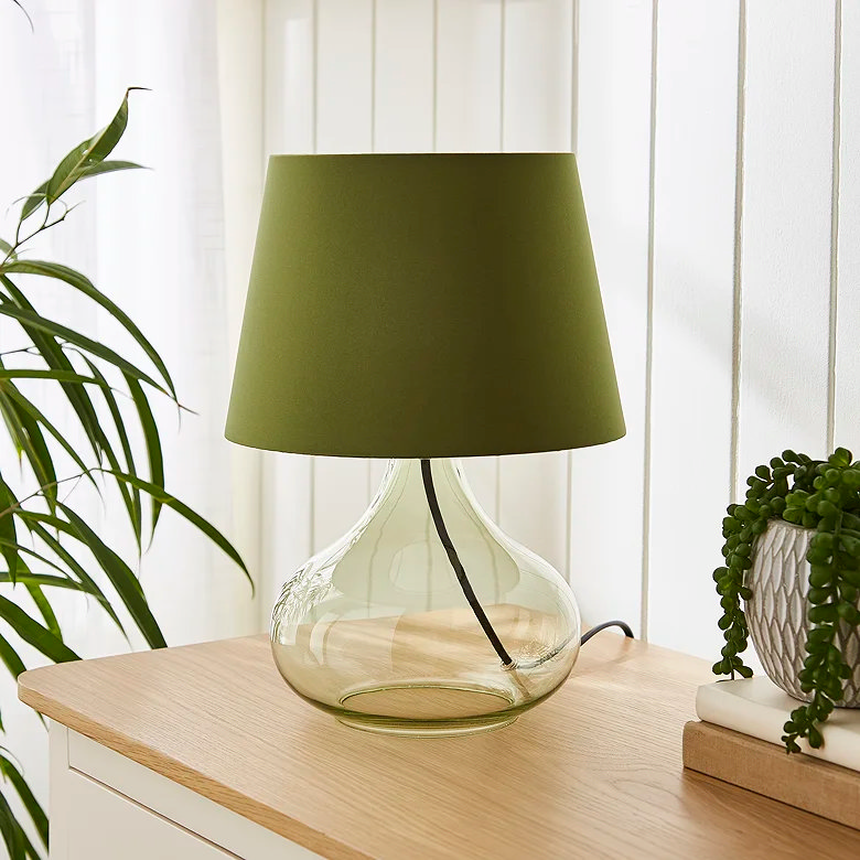 olive green table lamp on drawers in bedroom