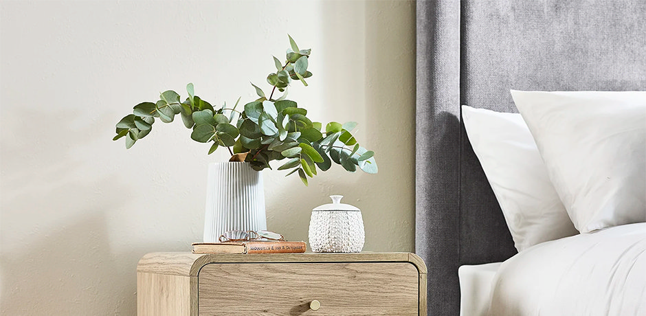 clean fake plant on bedside table in bedroom