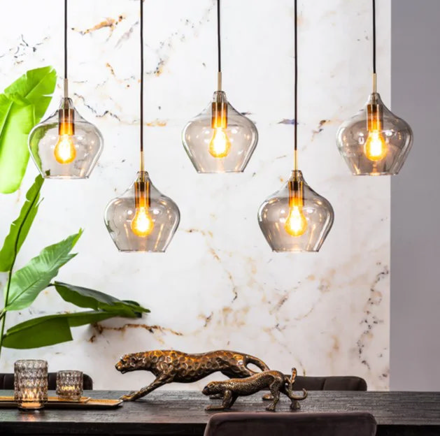 cluster glass pendant lights over dining table with warm bulbs