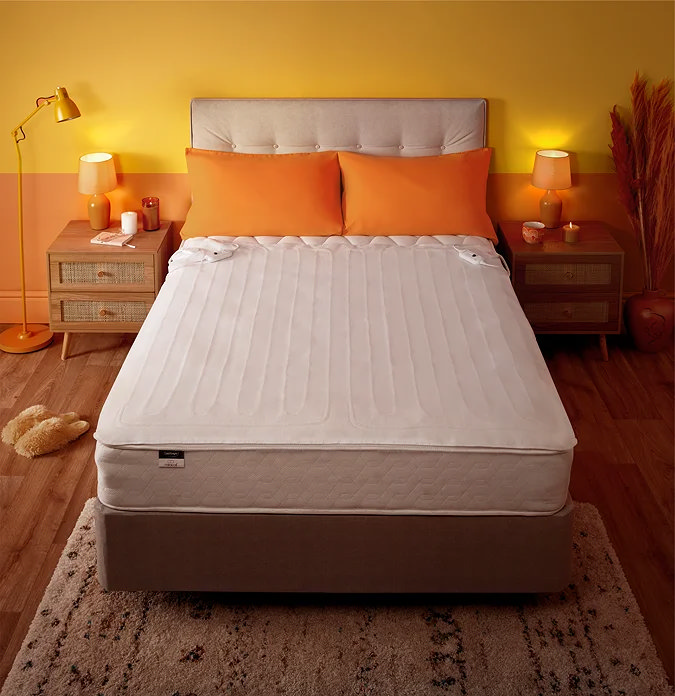 Butter yellow colour-blocked bedroom with white bedding and orange cushions.