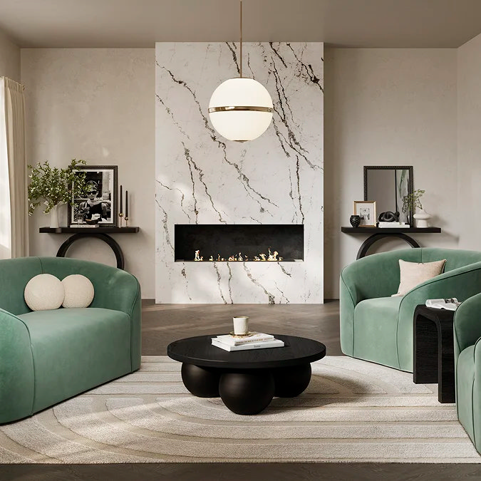 Modern round black coffee table styled with stacked books and a candle in a contemporary living room