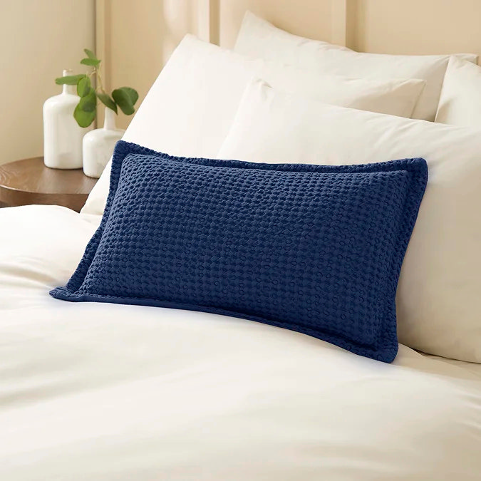 Navy textured cushion on white bedding