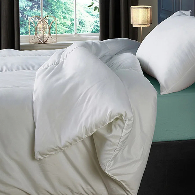 White duvet draped over bed edge