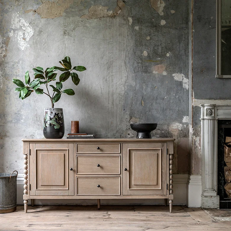 oak sideboard against distressed wall with earthy textures and natural styling