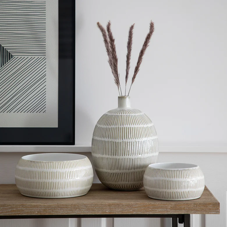 textured ceramic vase and bowls in neutral tones with pampas grass on wooden console