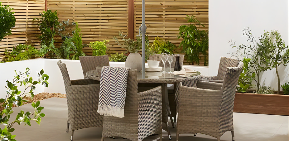 Luxury garden furniture set with round outdoor dining table, woven chairs and parasol on a modern patio