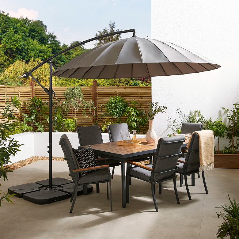 Large hanging garden parasol shading a luxury outdoor dining set on a modern patio