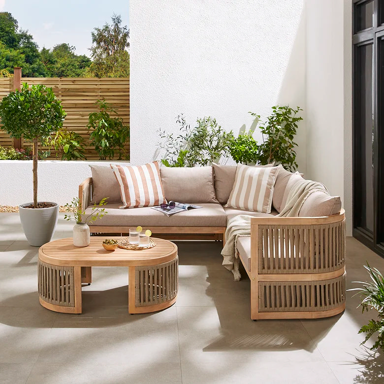 Luxury acacia wood corner garden sofa set with cushions and round coffee table creating a modern outdoor lounge area