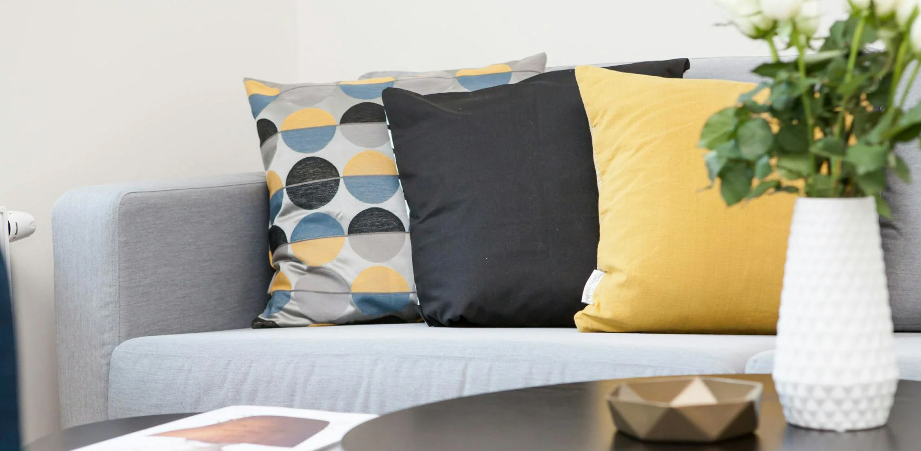 Sofa with mismatched cushions showing common styling mistakes in colour, size, and arrangement.