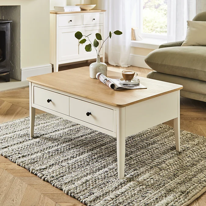 White painted wooden coffee table with oak top and storage drawers, styled in a modern living room.