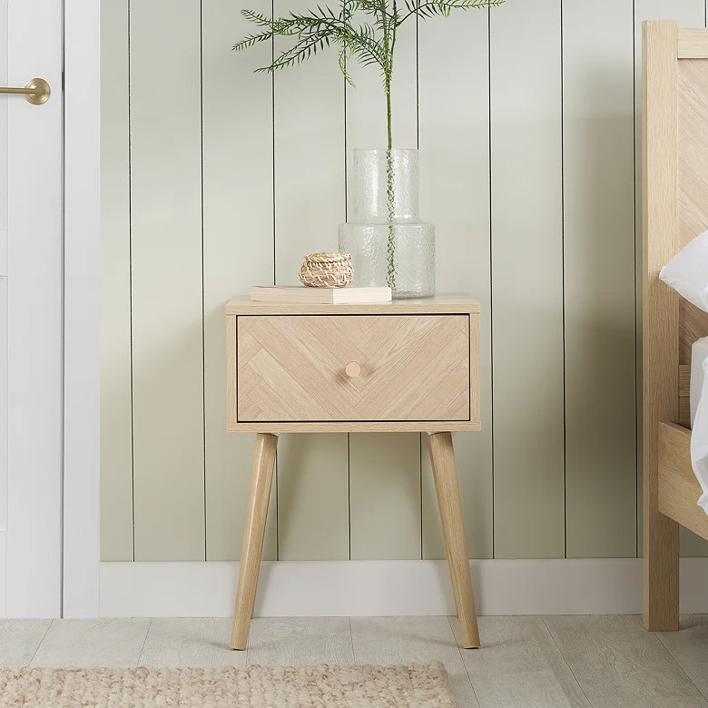 bedroom with light oak bedside table featuring herringbone drawer front and tapered legs