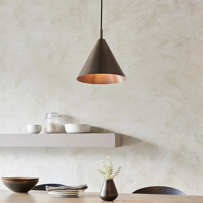 minimalist metal pendant light over dining table with warm glow