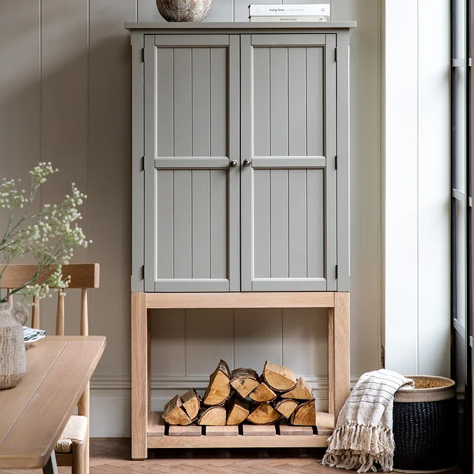 Grey cupboard on oak base with firewood.