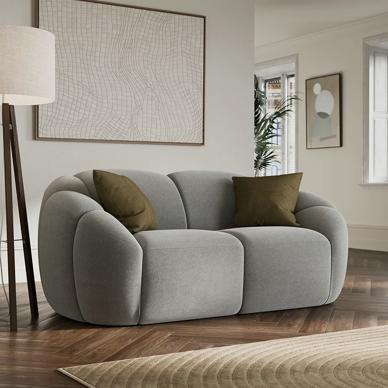 Tripod floor lamp beside curved grey sofa in modern living room