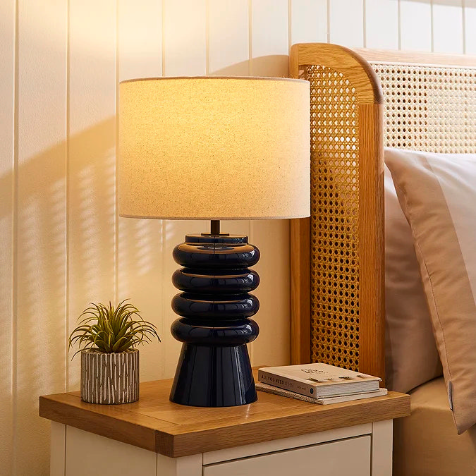 Navy table lamp with cream shade on nightstand