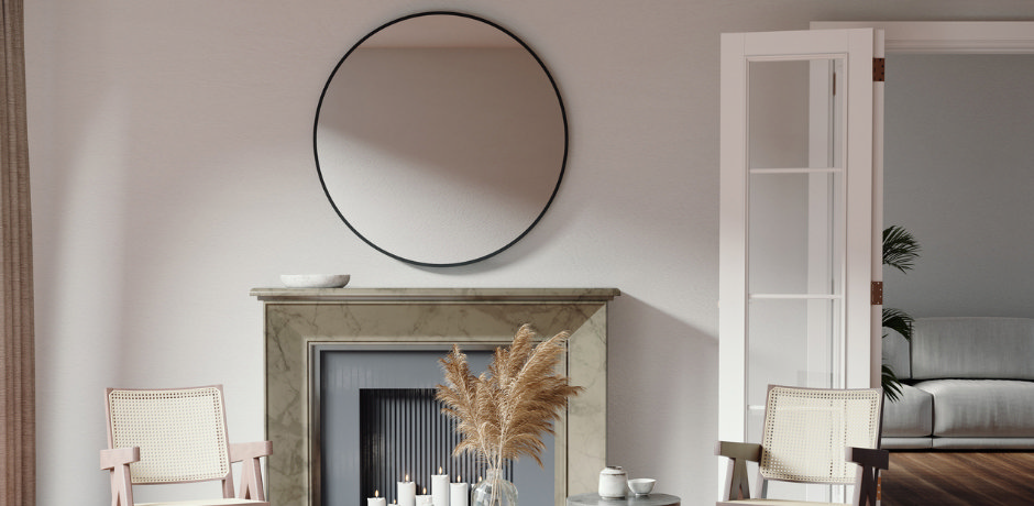 Round black-framed wall mirror above a fireplace, modern living room mirror idea to reflect light and create space.