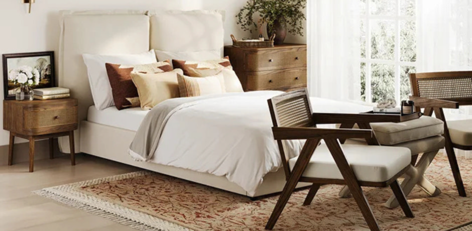 Open-weave wooden bedroom chair with stool in small neutral room