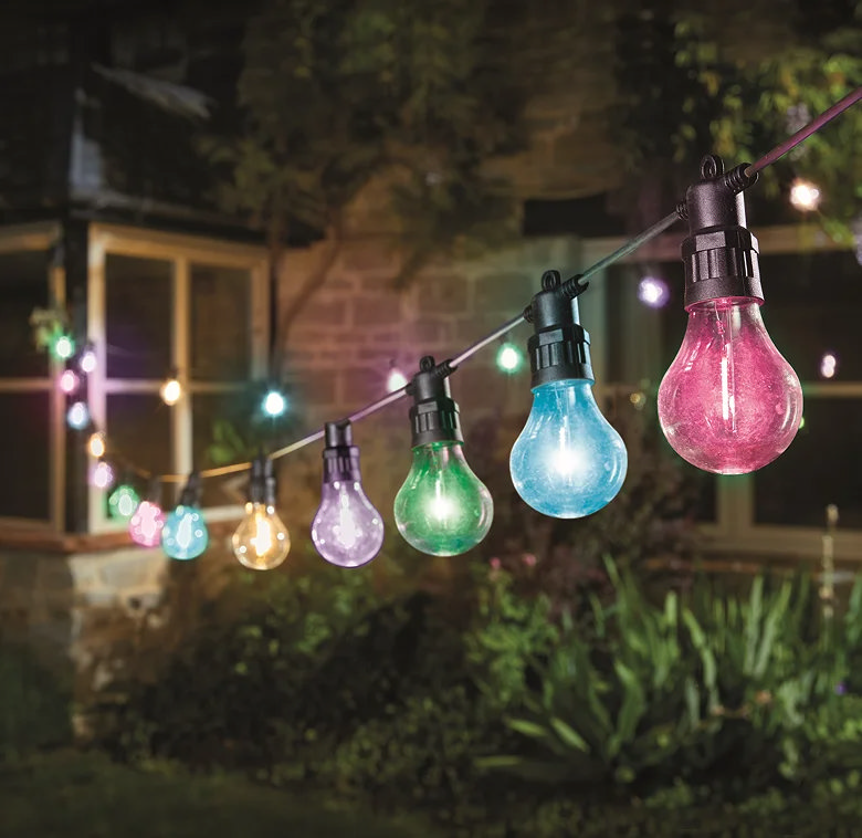 Multicolour festoon garden lights hanging across a patio at night