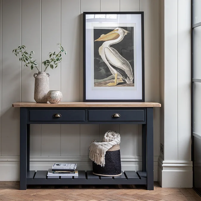 Painted horizontal wall panels behind a console table creating the effect of a wider hallway.