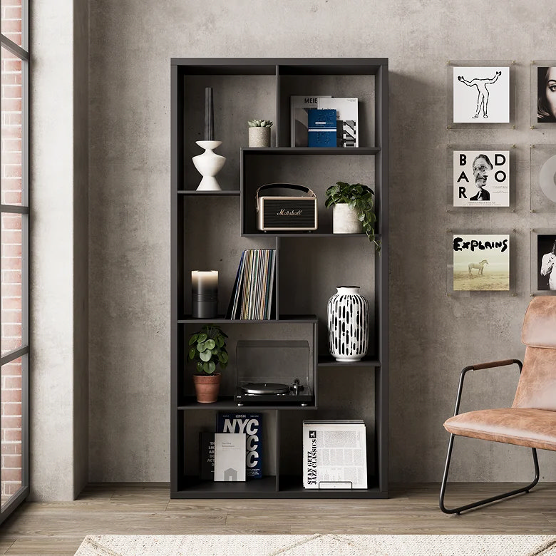 Black abstract bookshelf styled with books, plants, ceramics and a record player.