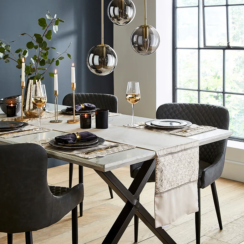 Dining table styled with table runner, candles and pendant lights